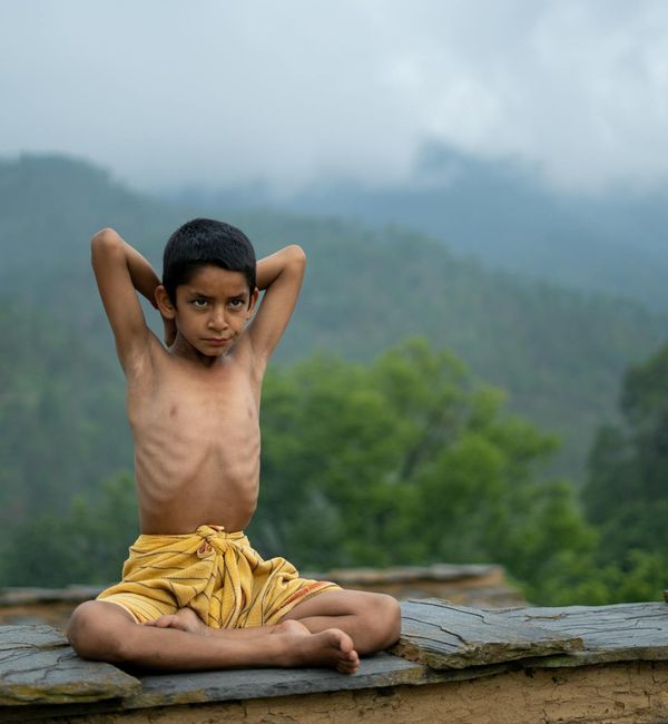 Person meditating peacefully outdoors with a natural background.