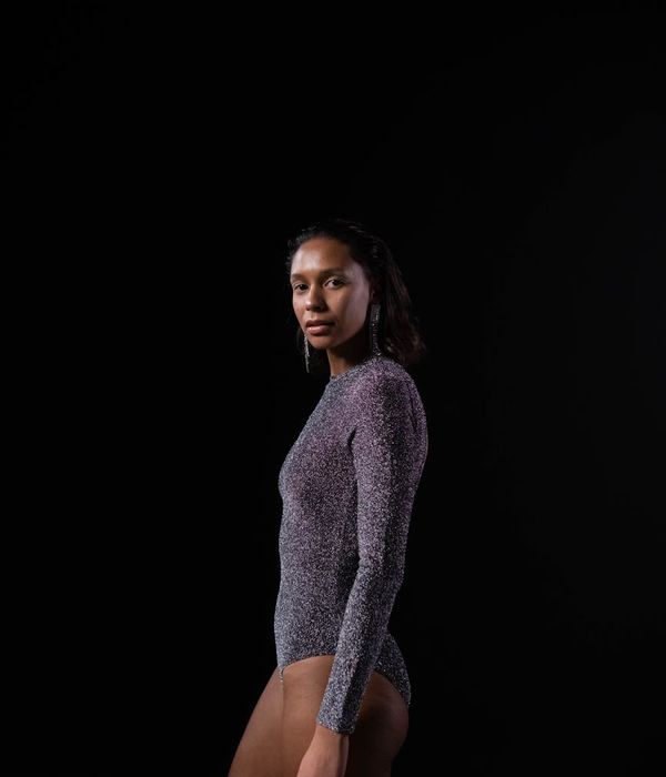Woman in a calm yoga pose in a studio with soft lighting.